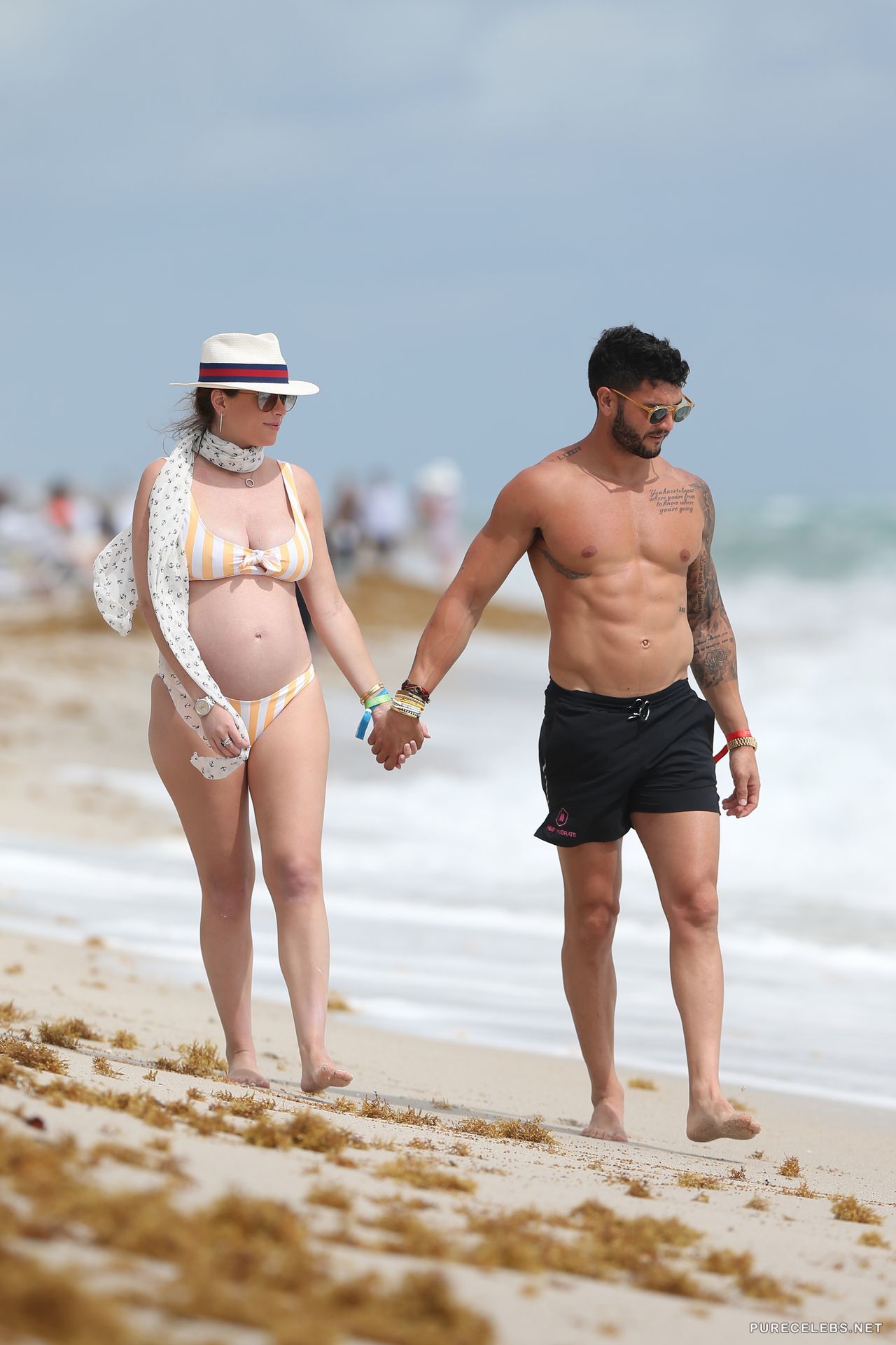 Chloe Melas takes a walk on the beach with her man and she shows off her pr...